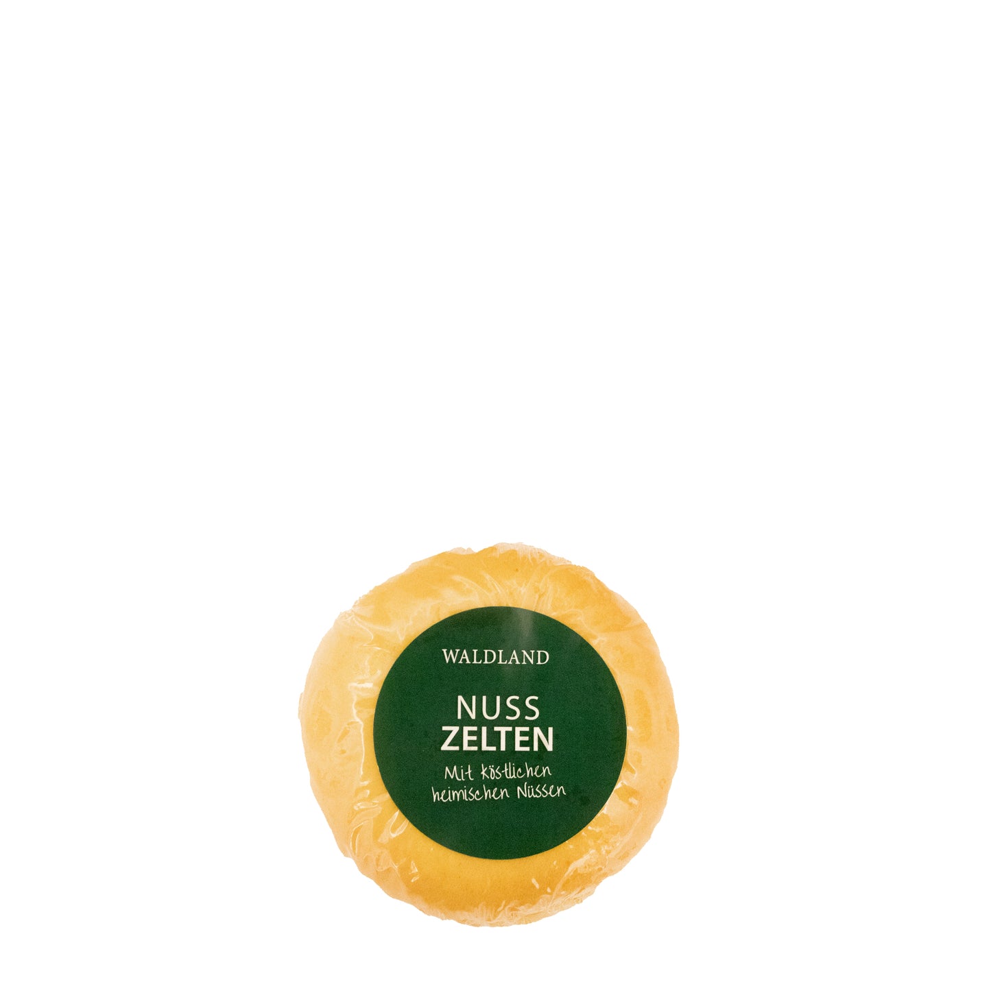 Der runde Nusszelten, in transparenter Folie verpackt liegt auf weißem Untergrund. Auf der Verpackung befindet sich ein dunkelgrünes Etikett mit weißer Aufschrift "Waldland Nusszelten – mit köstlichen heimischen Nüssen". Im Hintergrund sind angeschnittene Nusszelten, wo die saftige Füllung zu sehen ist.