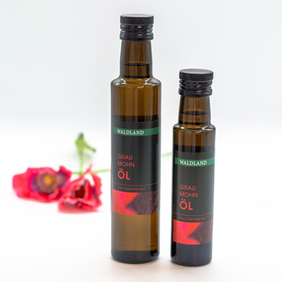Dunkle Glasflasche befüllt mit kaltgepresstem Graumohn Öl. Auf der Flasche befindet sich ein Produktetikett.