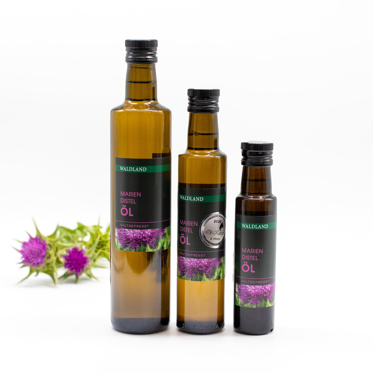 3 Dunkle Glasflasche befüllt mit kaltgepresstem Mariendistel Öl in verschiedenen Mengeneinheiten. Auf den Flaschen befindet sich ein Produktetikett.